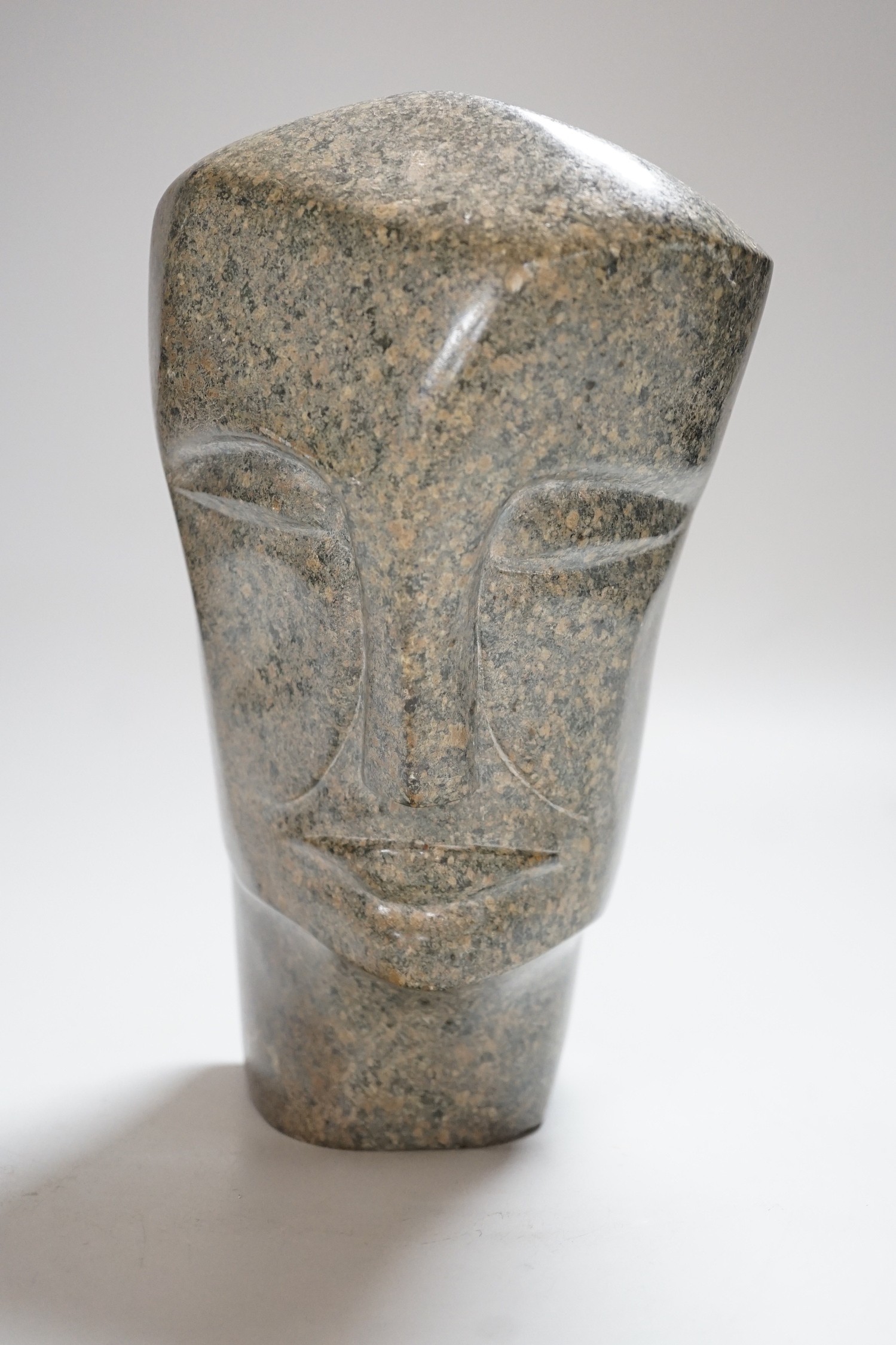 A carved stone head, 23cms high